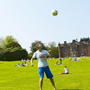 90x90 Student Heading Football behind Keele Hall