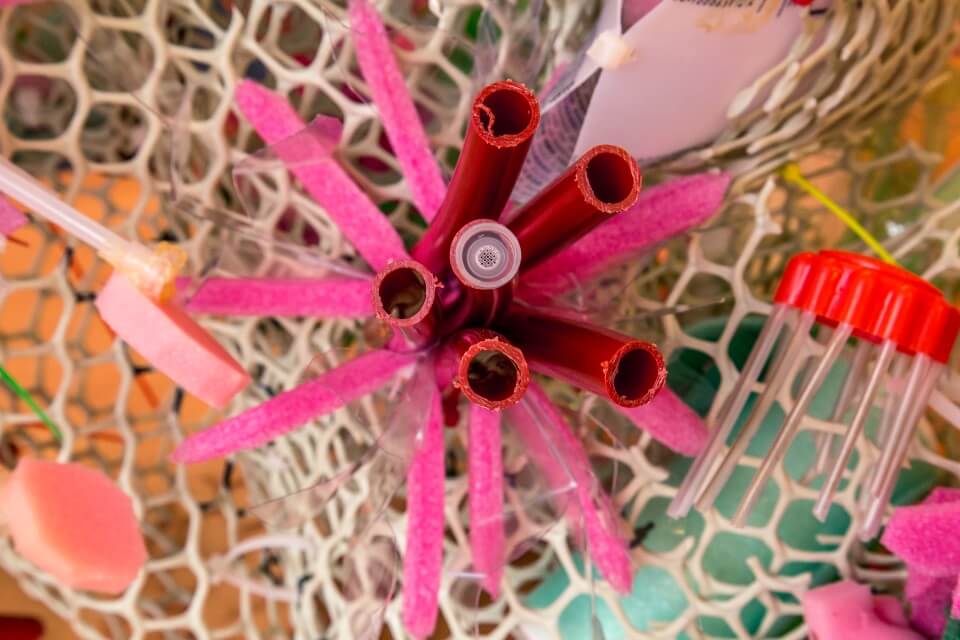 Image of plastic art up close including pink and red wires