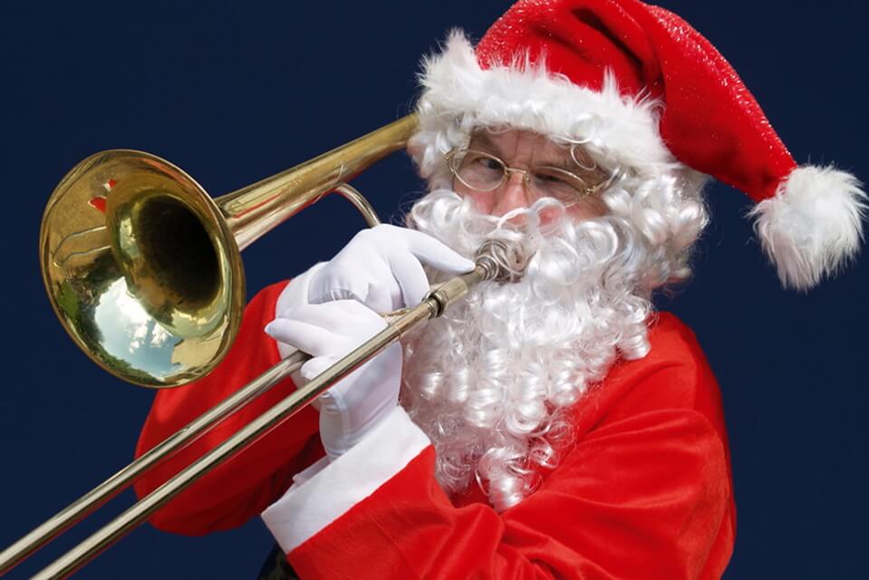 A photographic image of father christmas playing a trombone