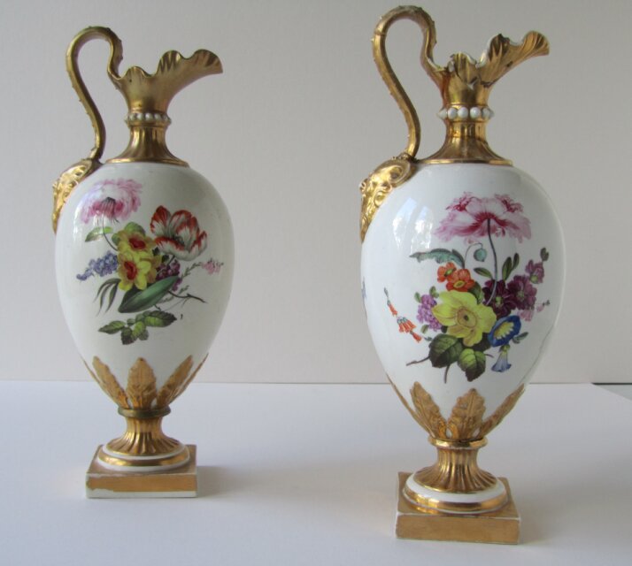 two patterned vases, white with gold handles and a decorative pattern in the middle.