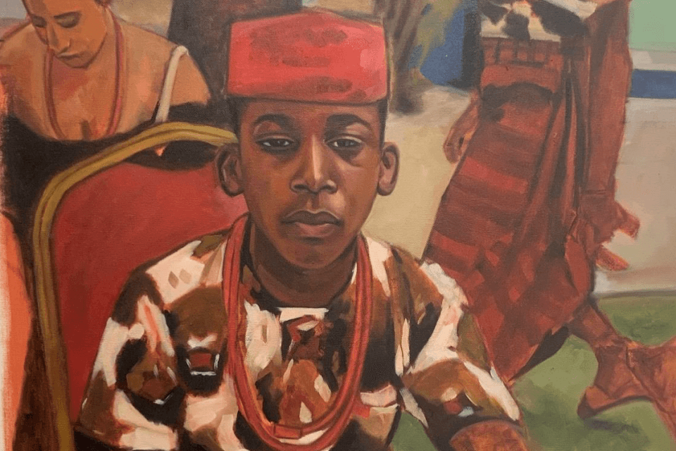 image of boy wearing red hat and necklace looking directly at you. Two female figures behind.