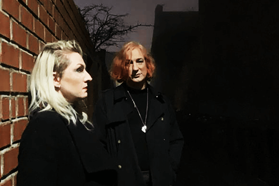 image of two performers in a dark street scene