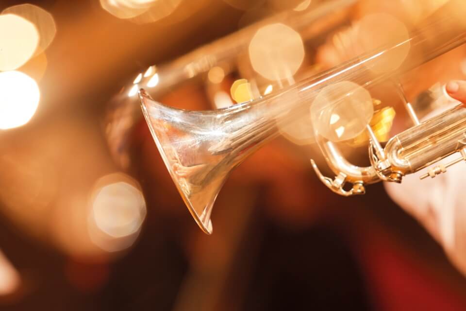 A picture of a trumpet up close, warm shiny gold tones