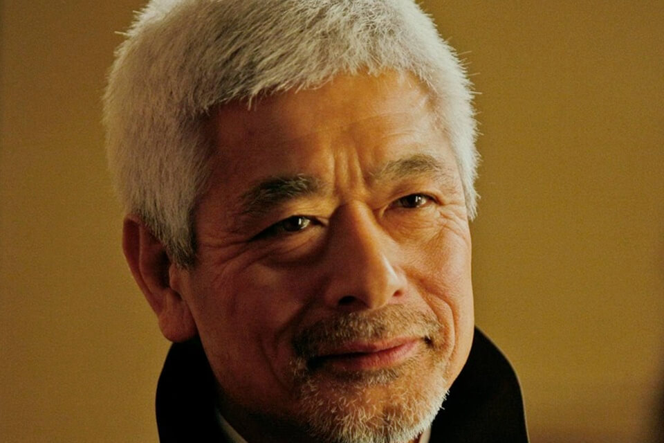 Japanese man with grey white short hair, smiling