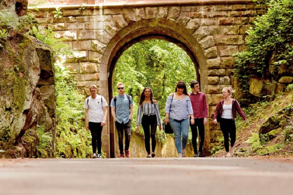 Group of people walking along Clock House Drive, Keele University