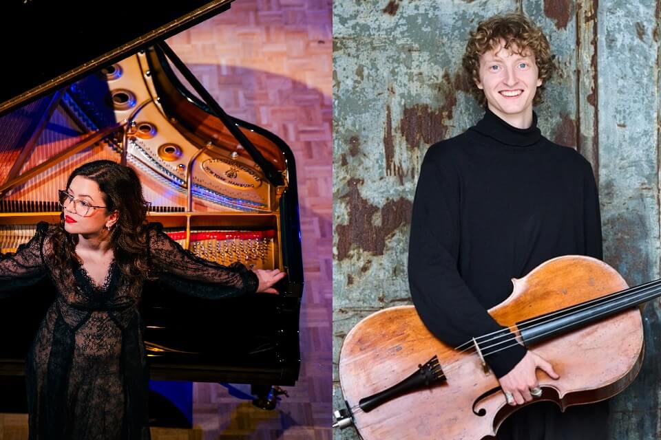 Williard standing holding cello under his arm and smiling