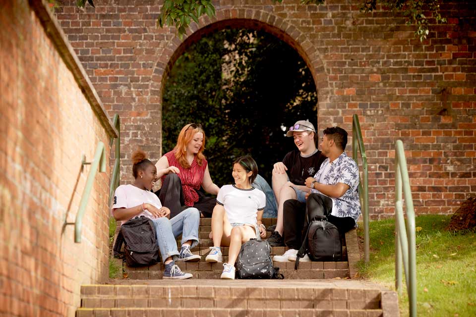 Students sitting outside Lindsay halls on Keele campus