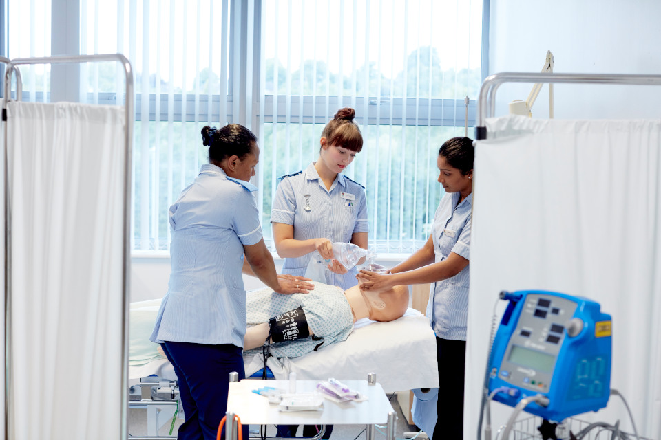 nursing students gather around a patient