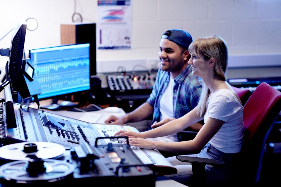 Music Technology students at a recording desk.