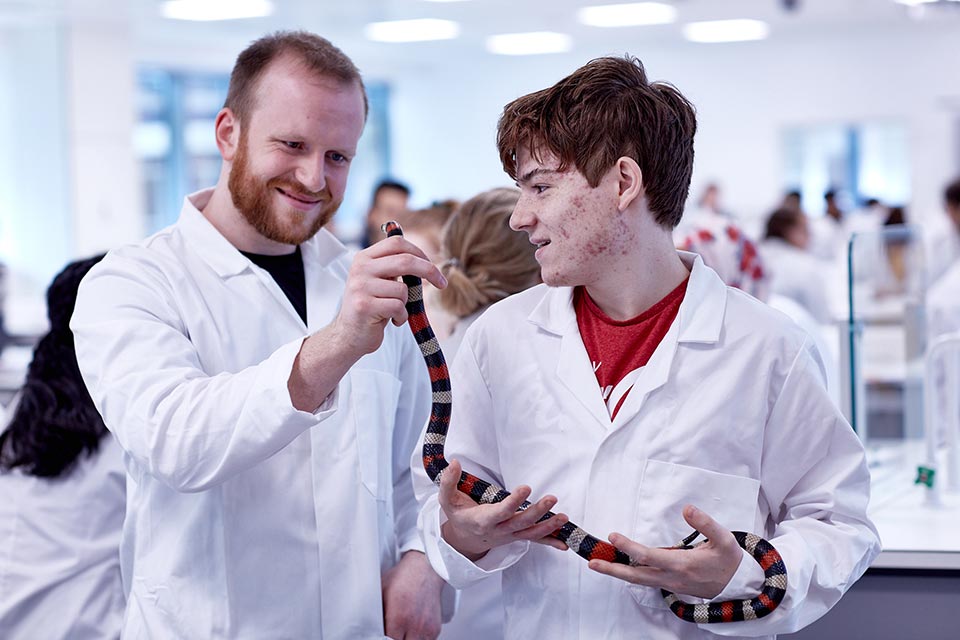Life Sciences student at Keele holding a snake.