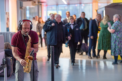 Saxophonist playing music as guests arrive 
