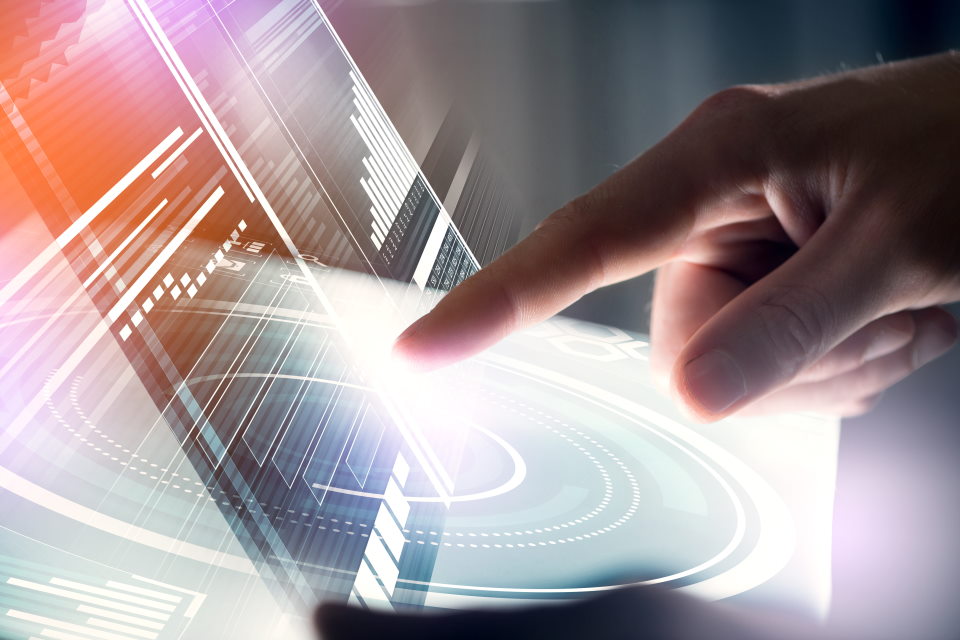 Photograph of a hand with finger pointing and interacting with a screen.