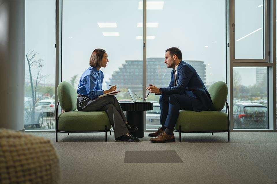 Man and woman having a meeting next to a large window
