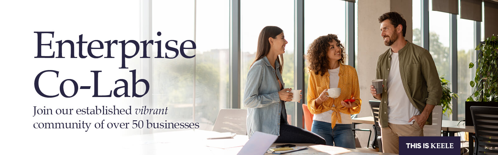 Photograph of a group of people seated around a coffee table inside the atrium of Keele University's Smart Innovation Hub, text overlay reads 'Coworking lounge' Keele Gateway, Midlands Engine and ERDF logos