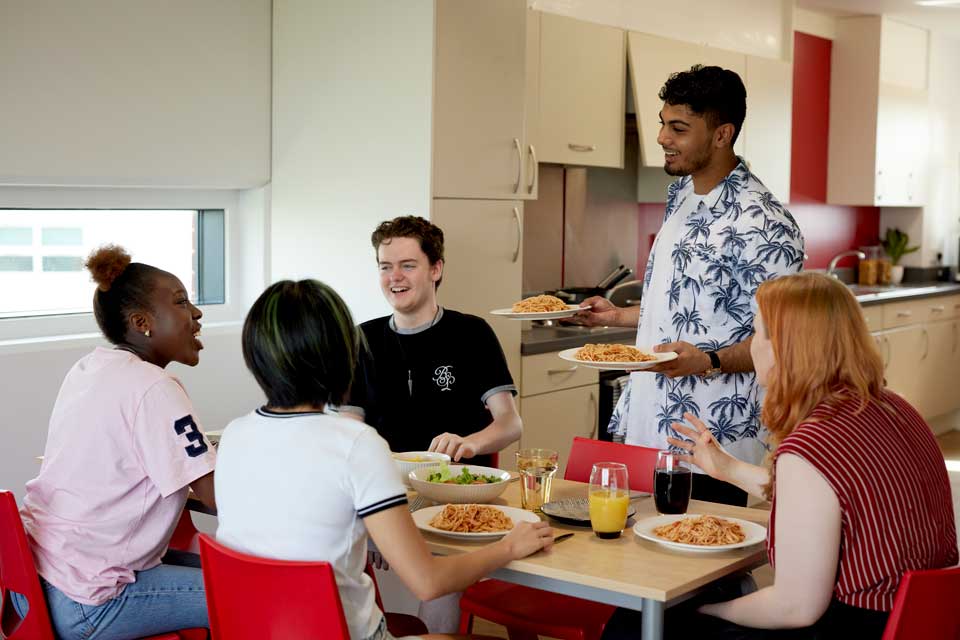 Students are sitting having dinner together in their halls of residence