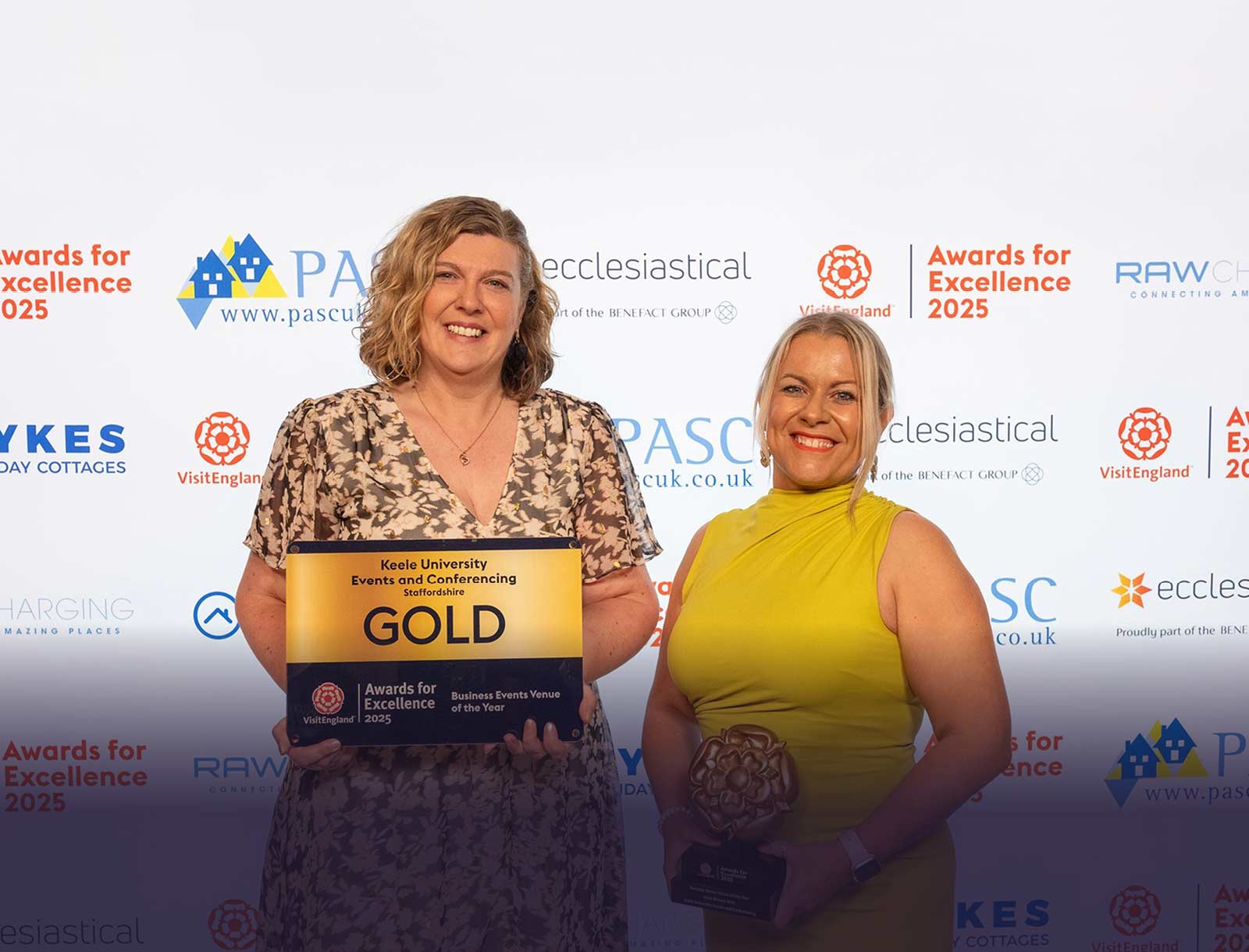 Two colleagues holding the GOLD VisitEngland award for excellence