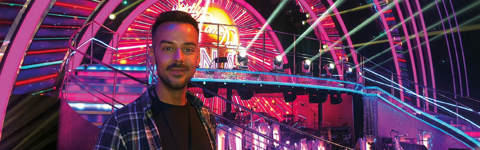 Man looking into the camera in front of strictly come dancing stage.