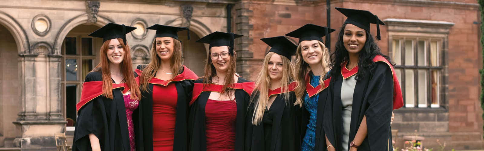 Students in graduate gowns stood outside Keele Hall