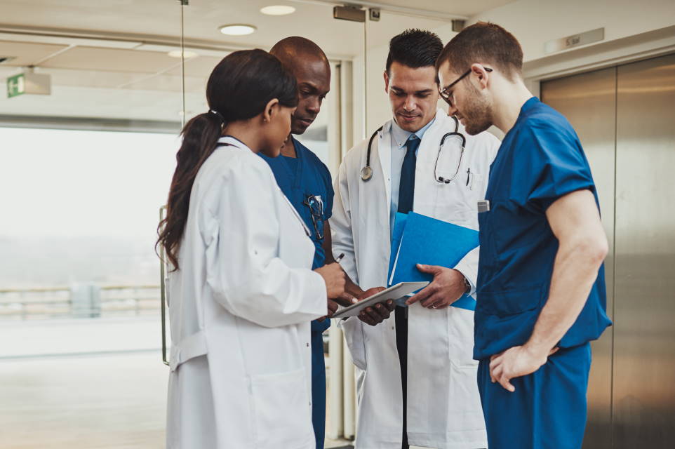 group of resident doctors viewing ebooks on a computer tablet