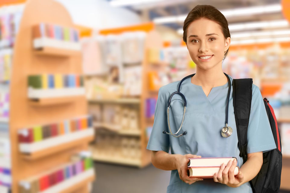 nursing student in the library, carrying a pile of books