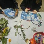 image of people sitting and making blue cycanotype prints with natural items