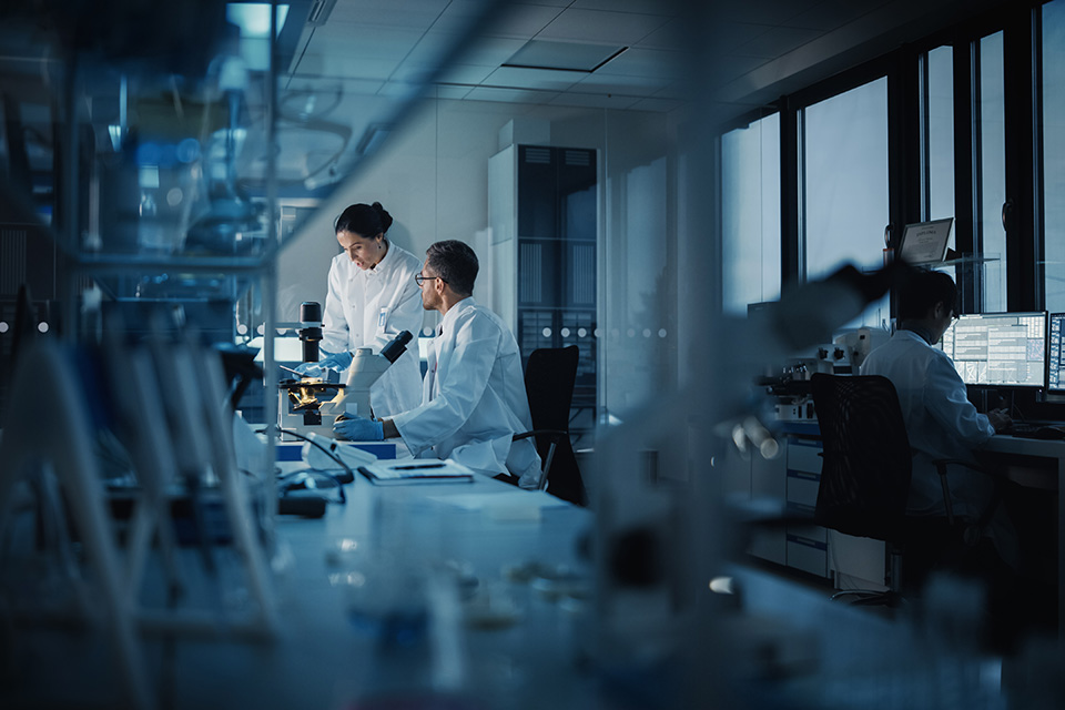 Two people in white lab coats in a laboratory setting
