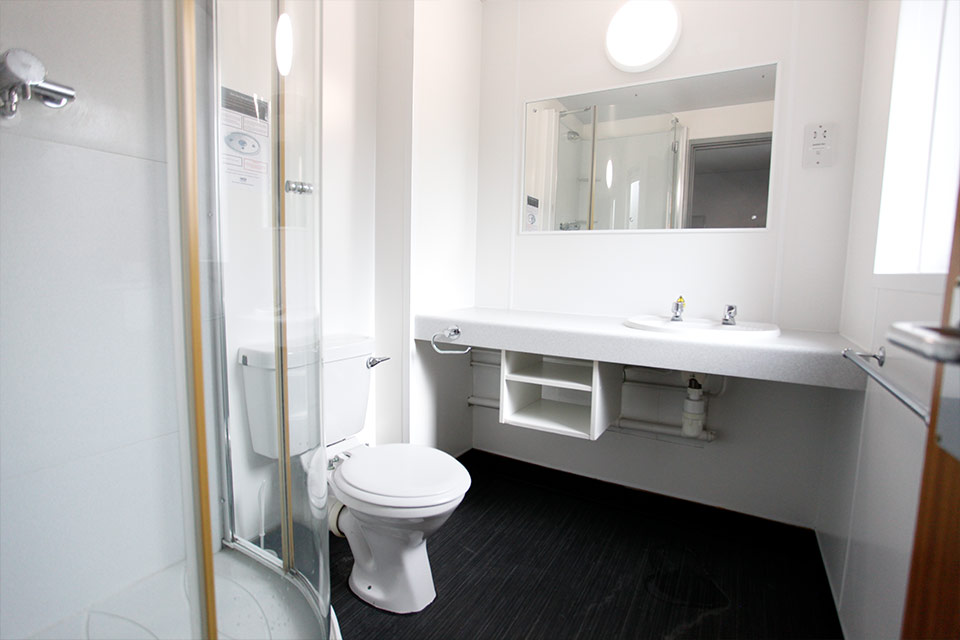 Interior of a student accommodation bathroom fitted with a toilet, sink and shower.