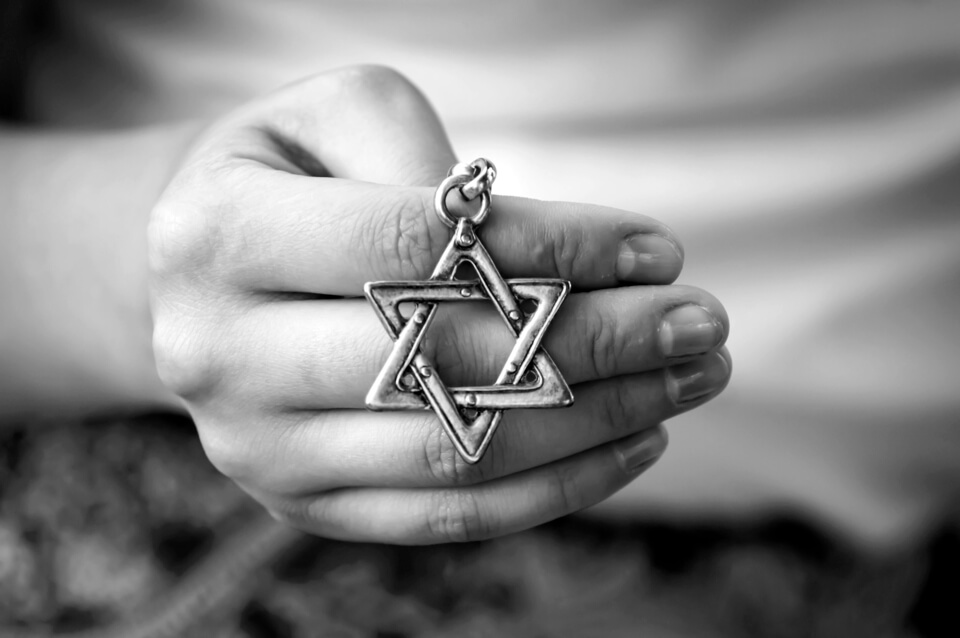 image of a hand holding a jewish symbol