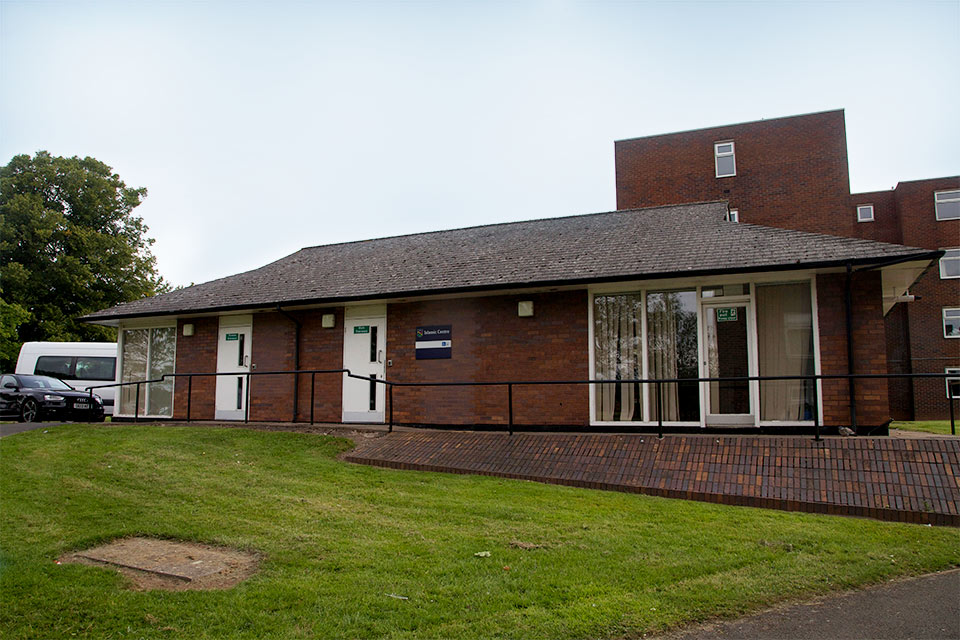 The outside of the Islamic Centre - a single story brick building with two white doors providing separate entrances for sisters and brothers.