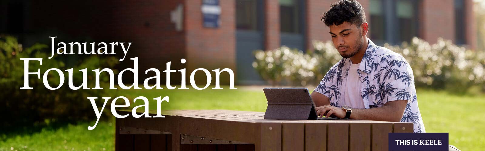 Student sitting outside accommodation, looking at digital tablet, with text overlay: 'January foundation year'