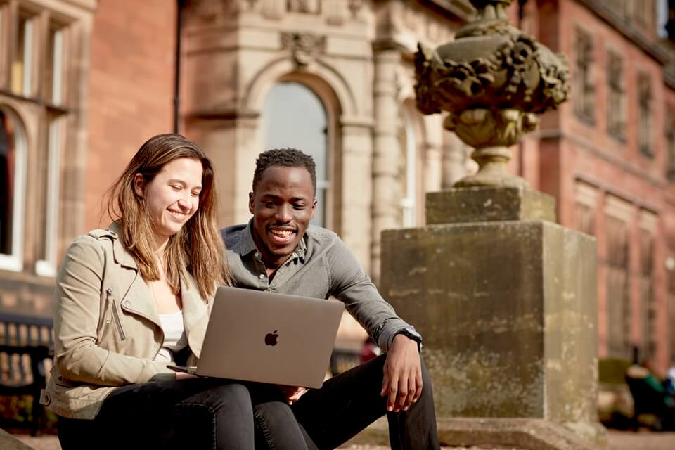 Students sitting outside Keele Hall
