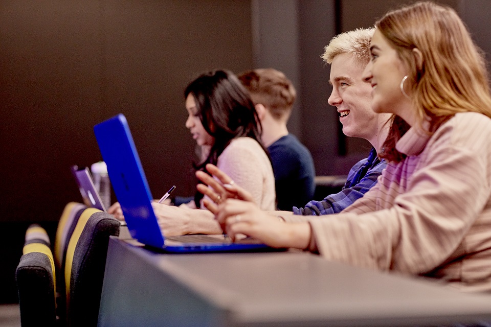 Students sitting with laptop in class