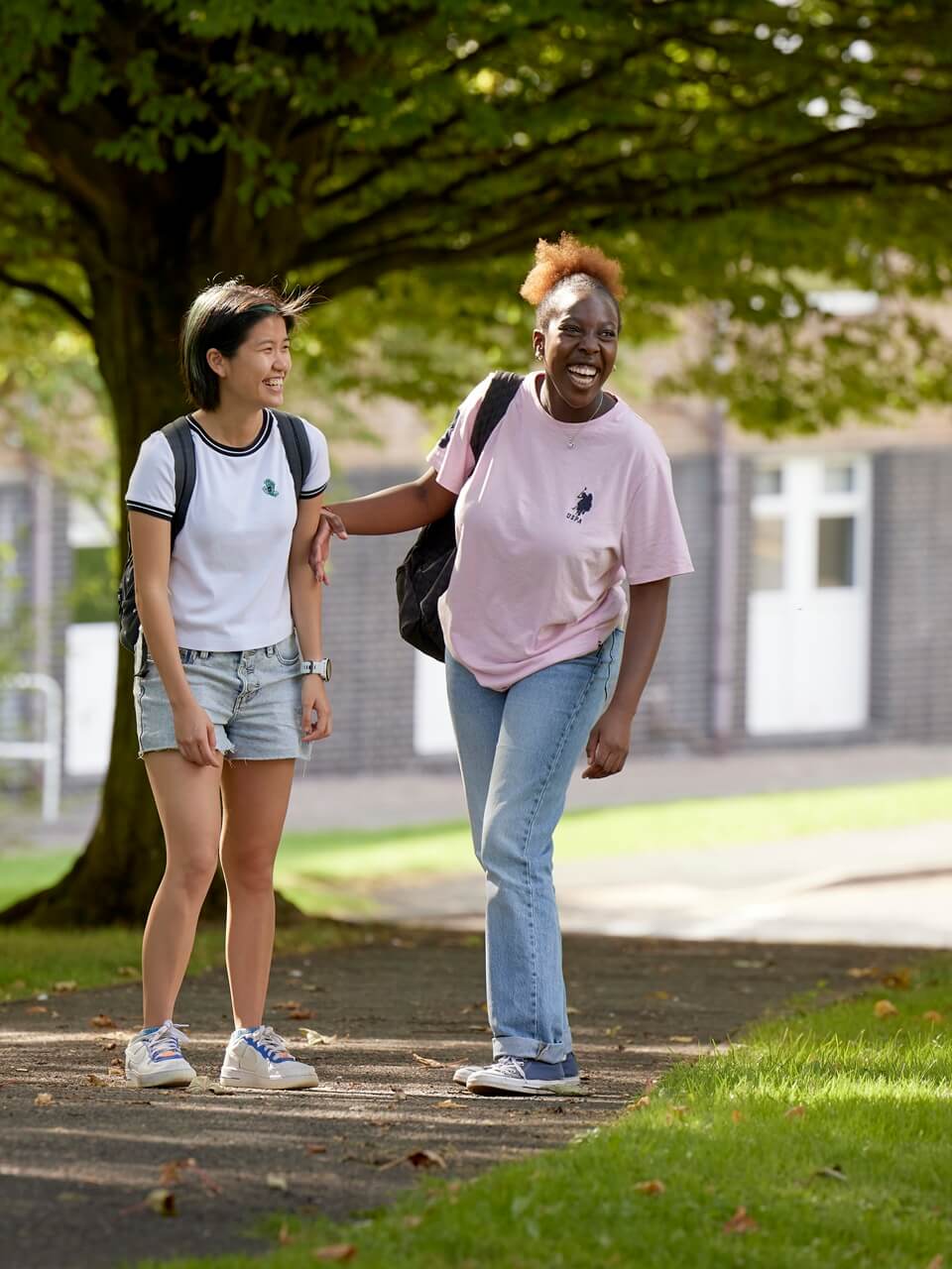 Two students standing outside accommodation on Keele campus.