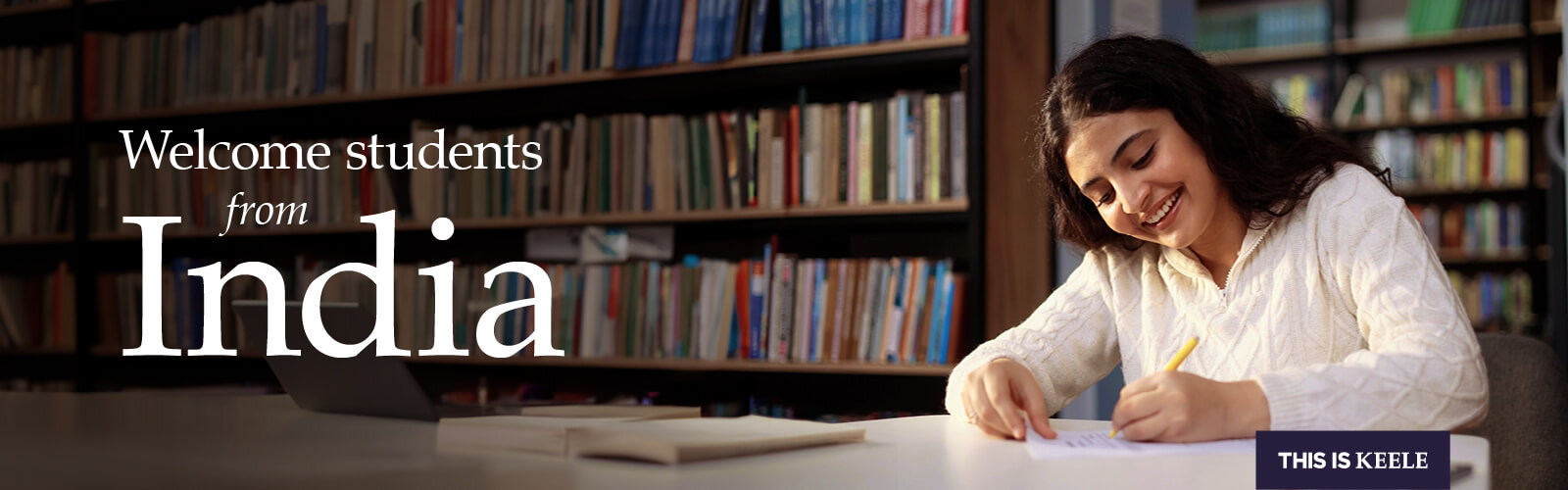 Student looking down writing and smiling.