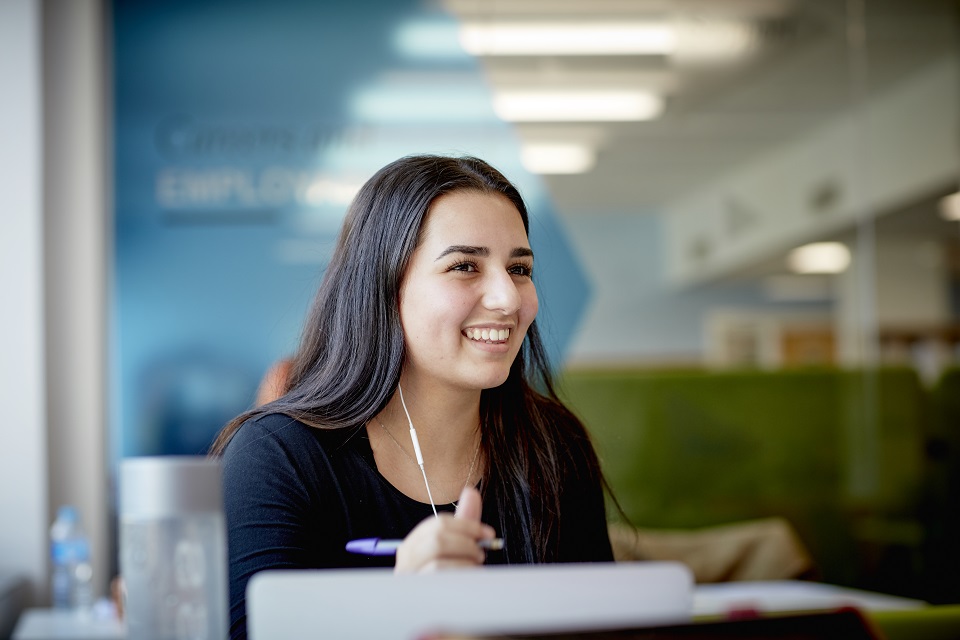 Student in library smiling 