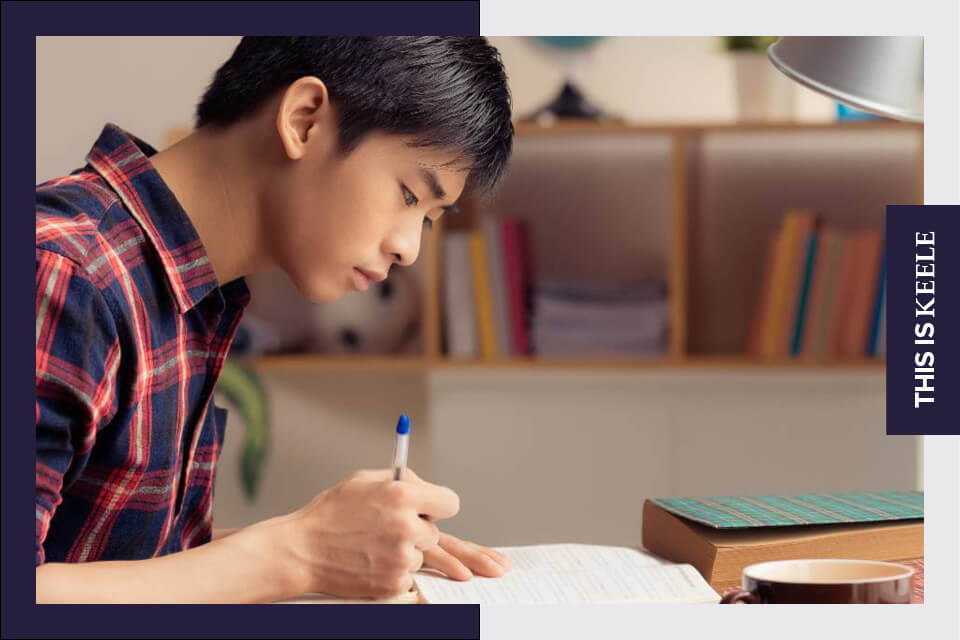  Student writing personal statement at desk
