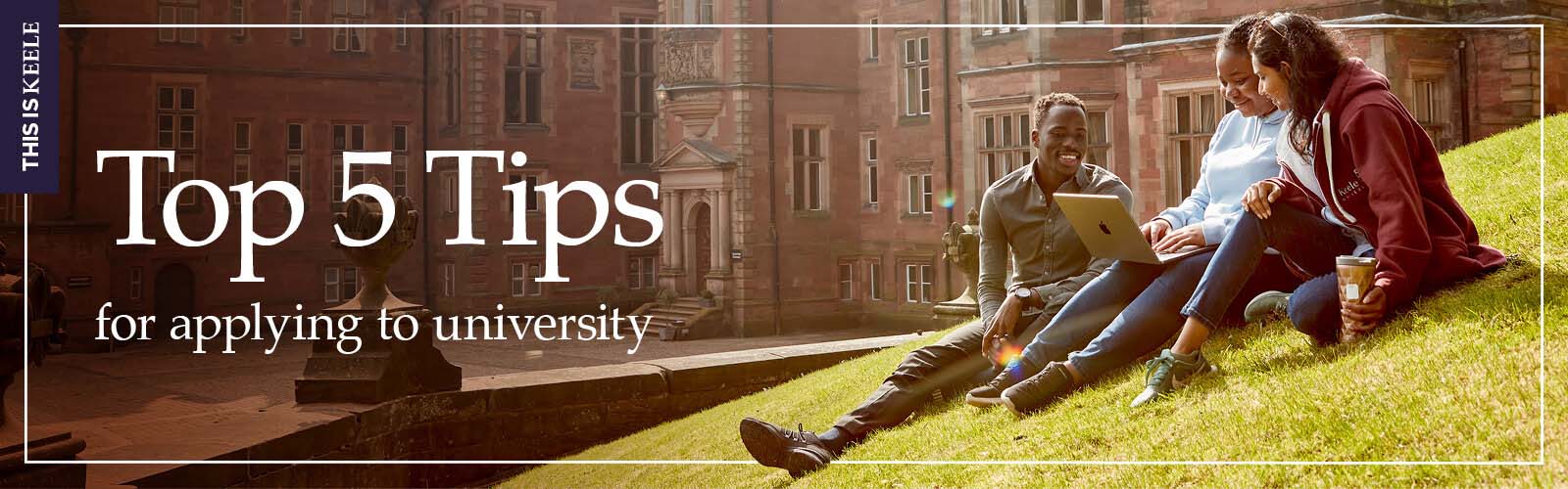 Keele students looking at laptop at the front of Keele Hall