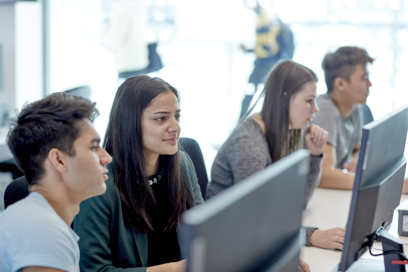 A group of students sat around a computer.