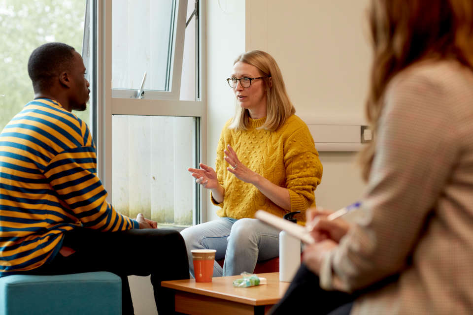 A lecturer and a student talking in classroom