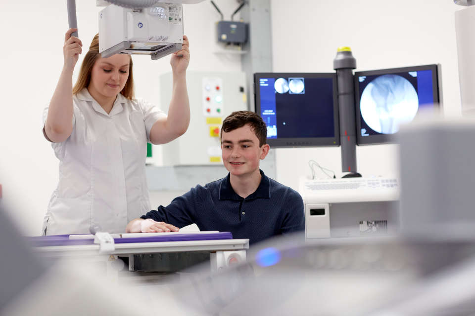 A radiography student with a patient