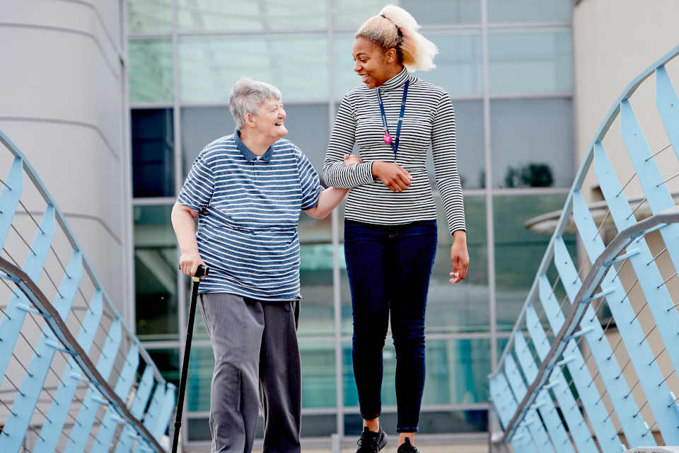 A Keele University student walking with a patient 