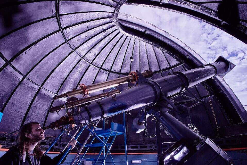 student looking through telescope