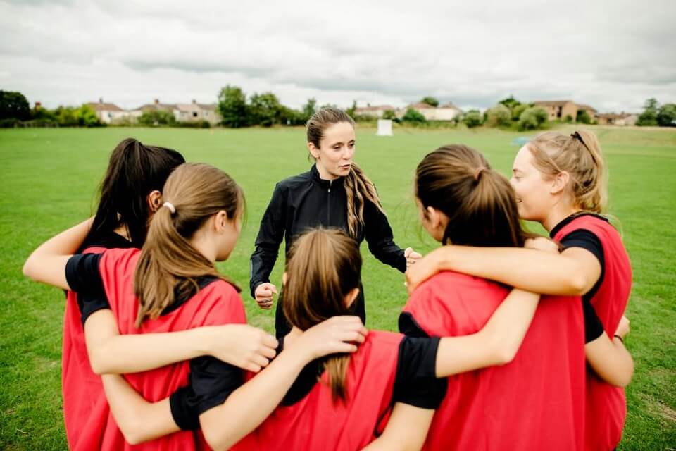 Coach talking to group of women football players