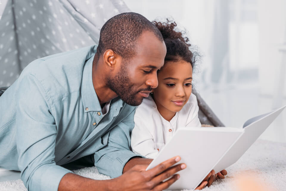 Image of a man and child looking at a book