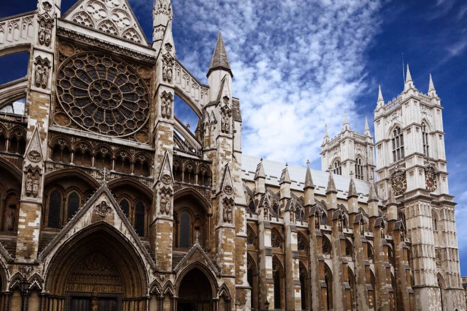 image of Westminster Abbey against a blue sky with flecky white clouds
