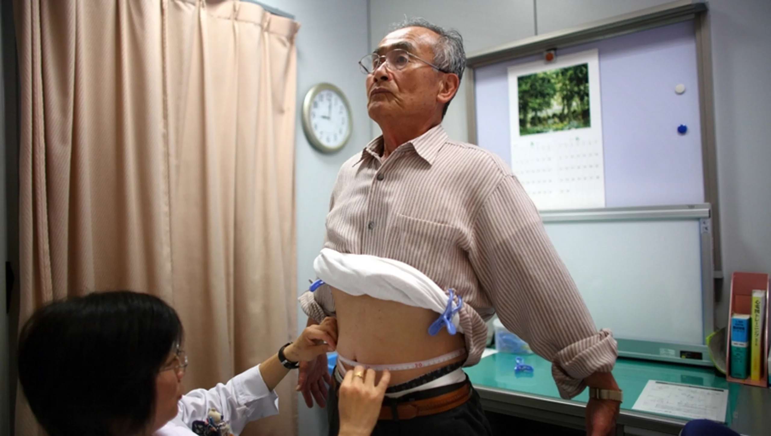 a man having his waist measured at the doctors