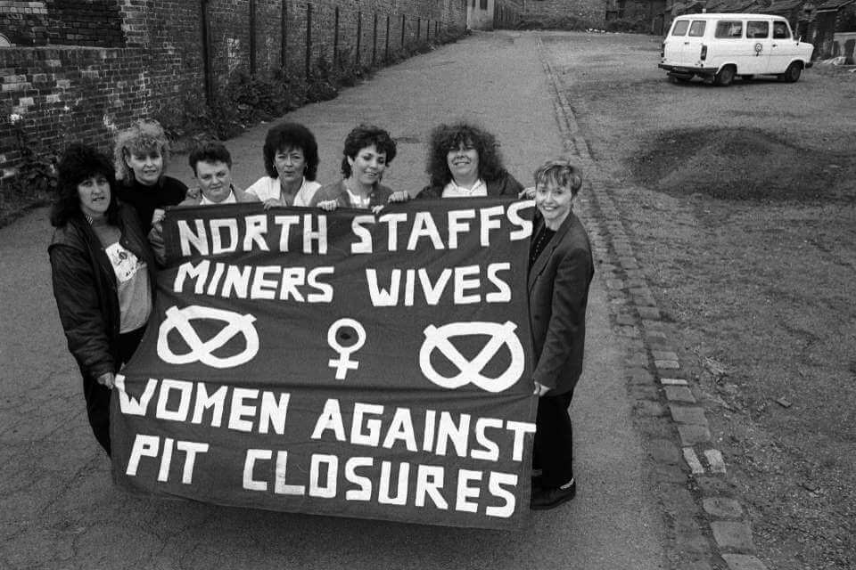 Three women with a banner that reads North Staffs Miners Wives Women Against Pit Closures